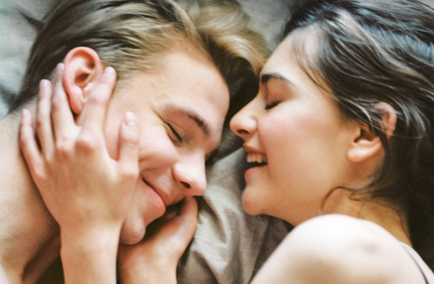 Giovane coppia a letto che si sorride